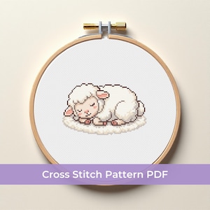 May include: A cross-stitch pattern of a sleeping sheep, stitched on white fabric and displayed in a wooden embroidery hoop. The sheep is white with pink accents, resting on a fluffy cloud-like base. The text "Cross Stitch Pattern PDF" is displayed on a purple banner.