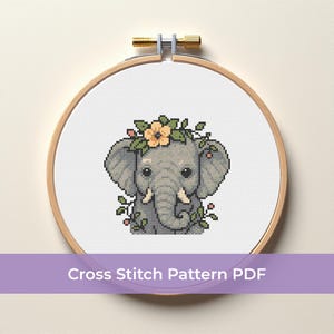 May include: A cross-stitch pattern of a grey elephant wearing a floral crown, surrounded by green leaves and pink berries. The design is displayed in a wooden embroidery hoop. The text "Cross Stitch Pattern PDF" is at the bottom.