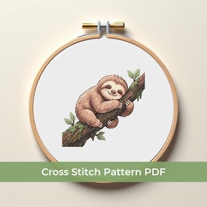 Könnte beinhalten: Ein Kreuzstichmuster mit einem lächelnden Faultier, das sich an einem Ast festhält. Das Faultier ist braun mit einem hellbraunen Gesicht, und der Ast hat grüne Blätter. Der Text "Cross Stitch Pattern PDF" befindet sich unten.