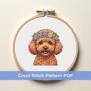 Può includere: Schema a punto croce di un barboncino marrone sorridente con una corona di fiori, all'interno di un telaio da ricamo in legno. Il testo "Cross Stitch Pattern PDF" è visualizzato in un banner blu sottostante.