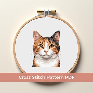 May include: A cross-stitch pattern of a cat's face, featuring orange, brown, black, and white fur. The design is displayed in a wooden embroidery hoop. The text "Cross Stitch Pattern PDF" is displayed at the bottom.