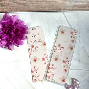 Peut inclure: Deux marque-pages à fleurs roses. Un marque-page dit "One More Chapter" et l'autre dit "Simply & Joy Creations".