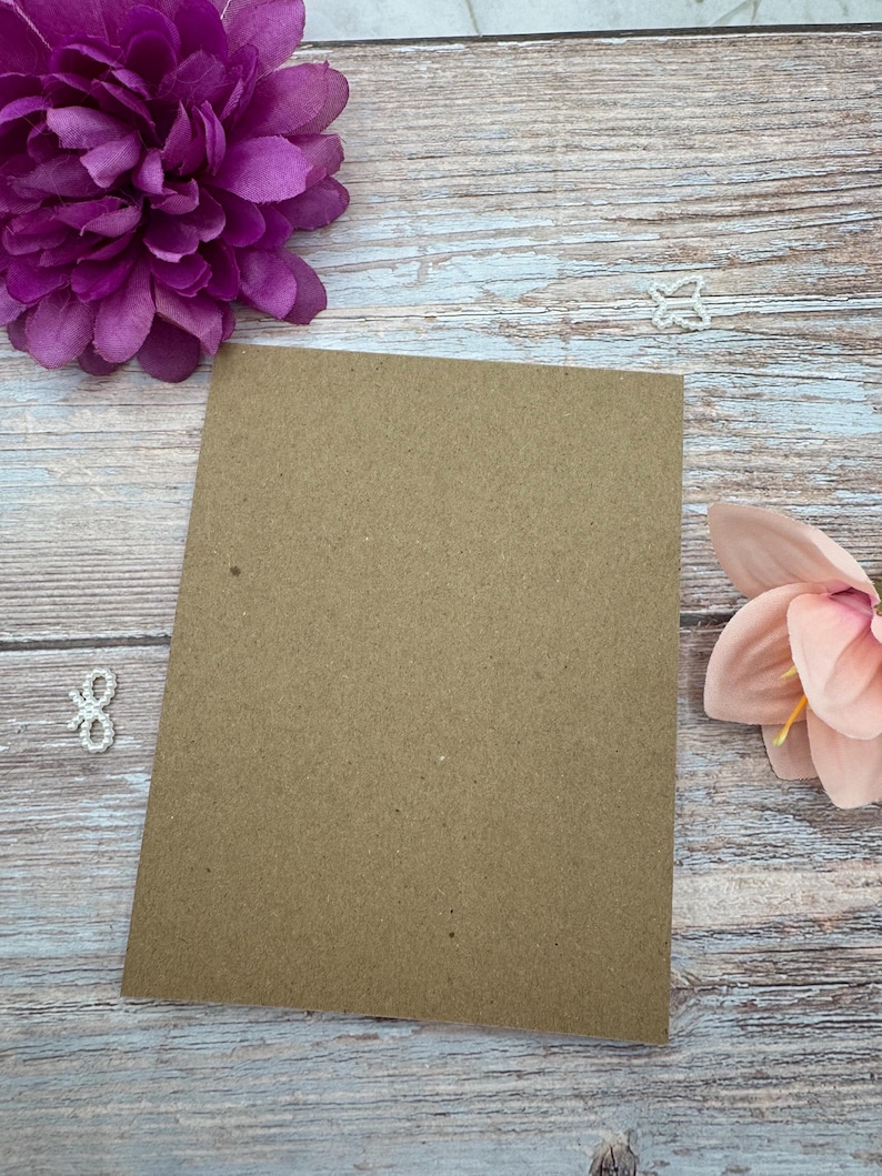 Peut inclure: Une feuille de papier cartonn&eacute; kraft marron de forme rectangulaire plac&eacute;e au centre. Ce papier cartonn&eacute; pr&eacute;sente une texture lisse et mate ainsi qu'une couleur marron uniforme sur toute sa surface, offrant un espace vierge pour divers projets.