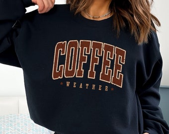 May include: Black sweatshirt with a brown vintage-style graphic that reads "COFFEE WEATHER" with stars on either side.
