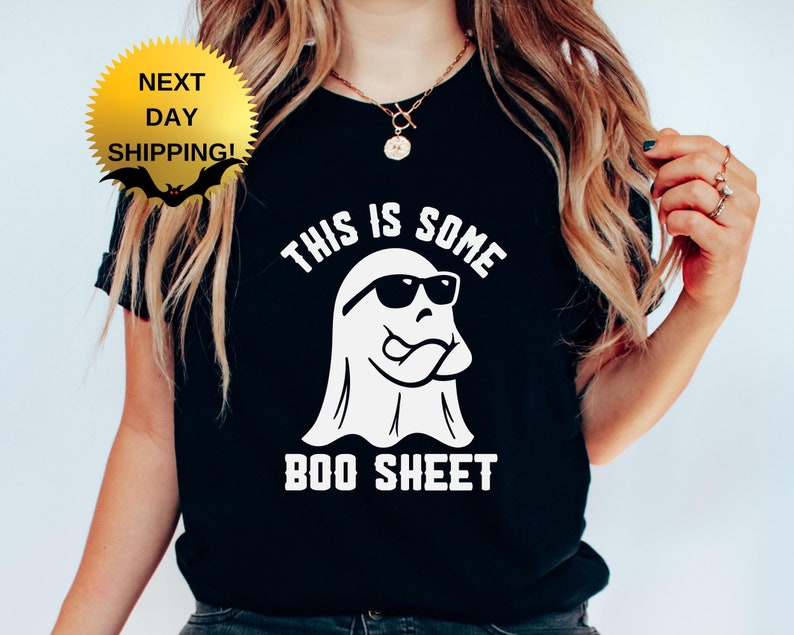 May include: Black t-shirt with a white ghost wearing sunglasses and the text "This is some boo sheet".
