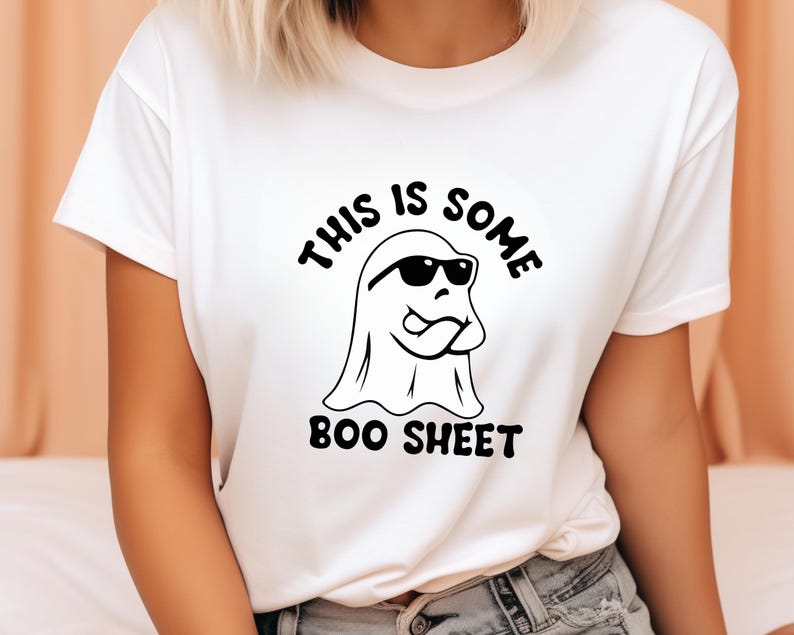 May include: White t-shirt with a black and white graphic of a ghost wearing sunglasses and the text "This is some boo sheet".