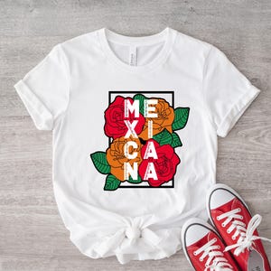 May include: White t-shirt with the word "MEXICANA" in a black frame, with red, orange, and green floral design. Red canvas sneakers with white laces are at the bottom of the image.
