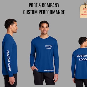 May include: A royal blue long-sleeve performance shirt featuring the text CUSTOM LOGO on the front chest, the lower front, the back, and the sleeve. The text PORT & COMPANY CUSTOM PERFORMANCE appears at the top of the image.