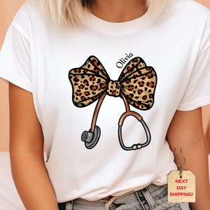 Personalized Coquette Nurse Shirt, Leopard Print Stethoscope Bow, Gift for Nurse, Nurse Graduation, Healthcare Shirt,Nurse Leopard Bow Shirt