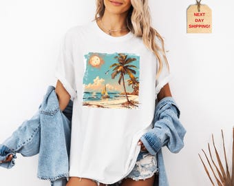 May include: White t-shirt with a vintage-style illustration of a beach scene with palm trees, a sailboat, and a full moon. The illustration is in a rectangular frame.