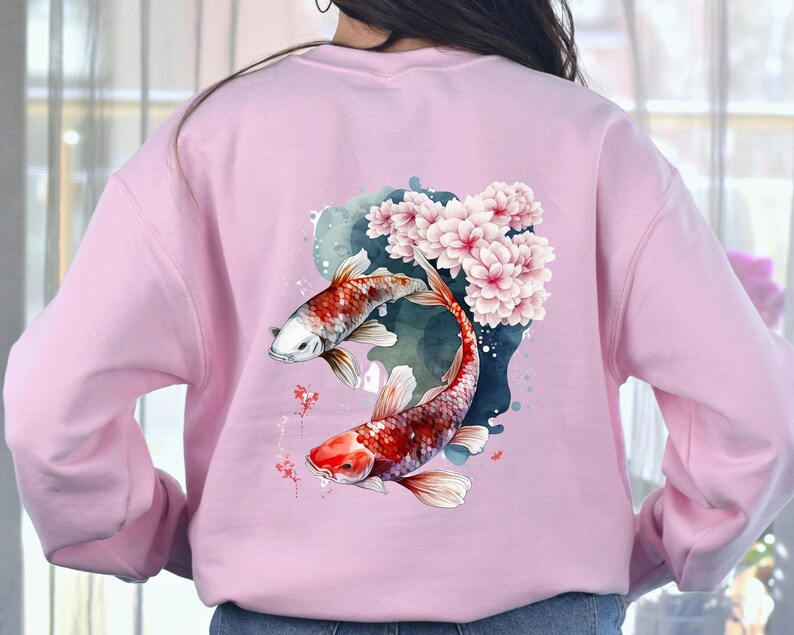 Puede incluir: Sudadera rosa con un dise&ntilde;o de acuarela de dos peces koi nadando a trav&eacute;s de flores de cerezo.