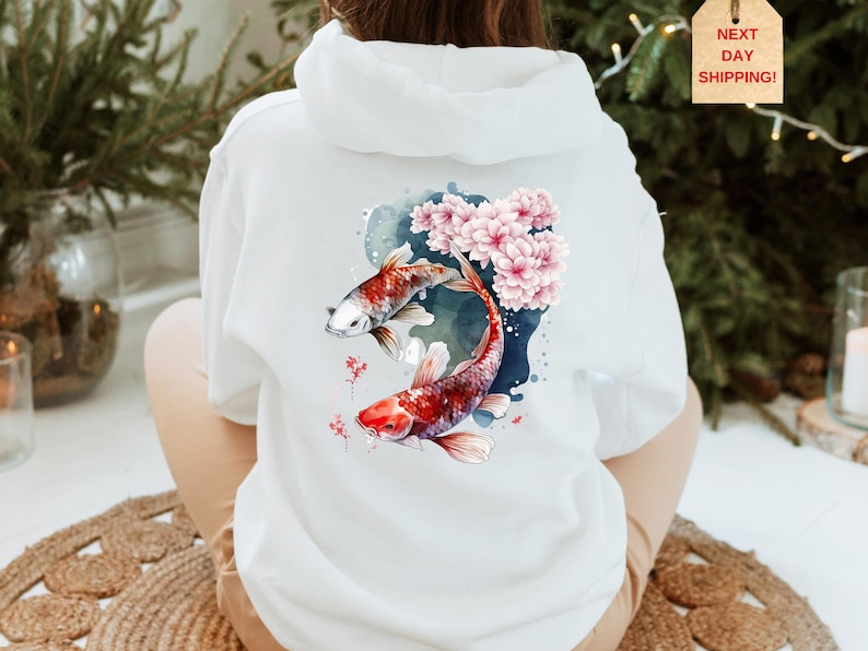 Puede incluir: Sudadera blanca con un dise&ntilde;o de acuarela de dos peces koi nadando a trav&eacute;s de flores de cerezo rosas.