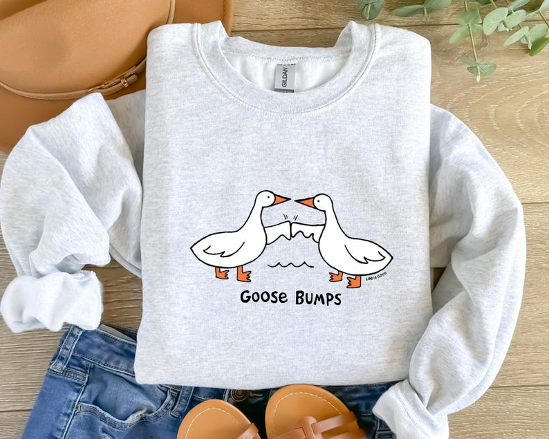 May include: A gray sweatshirt with a graphic of two geese bumping into each other. The text "Goose Bumps" is printed below the geese.