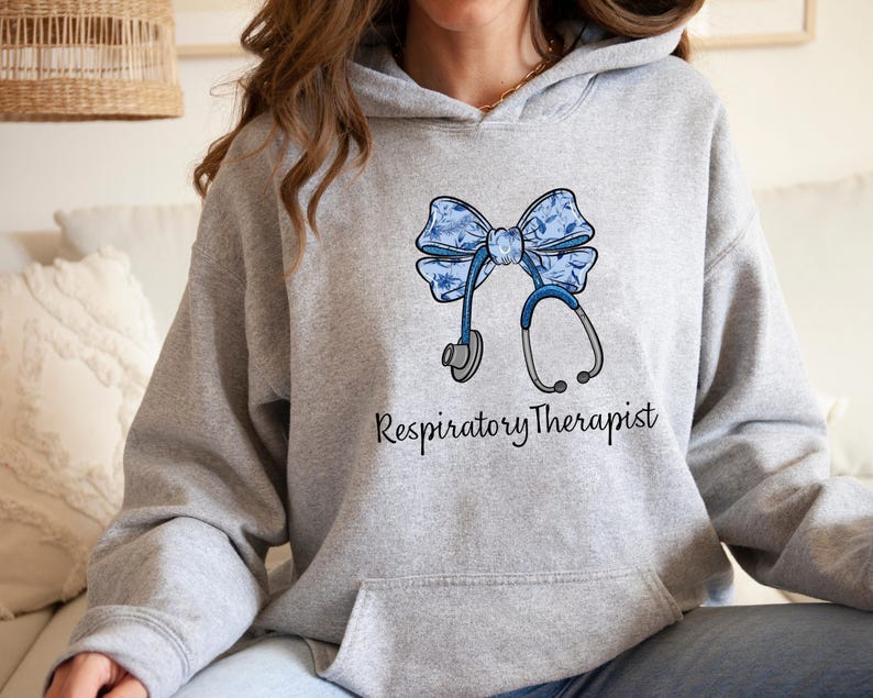 May include: A gray hoodie with a blue floral bow and stethoscope design. The text "Respiratory Therapist" is printed below the design.