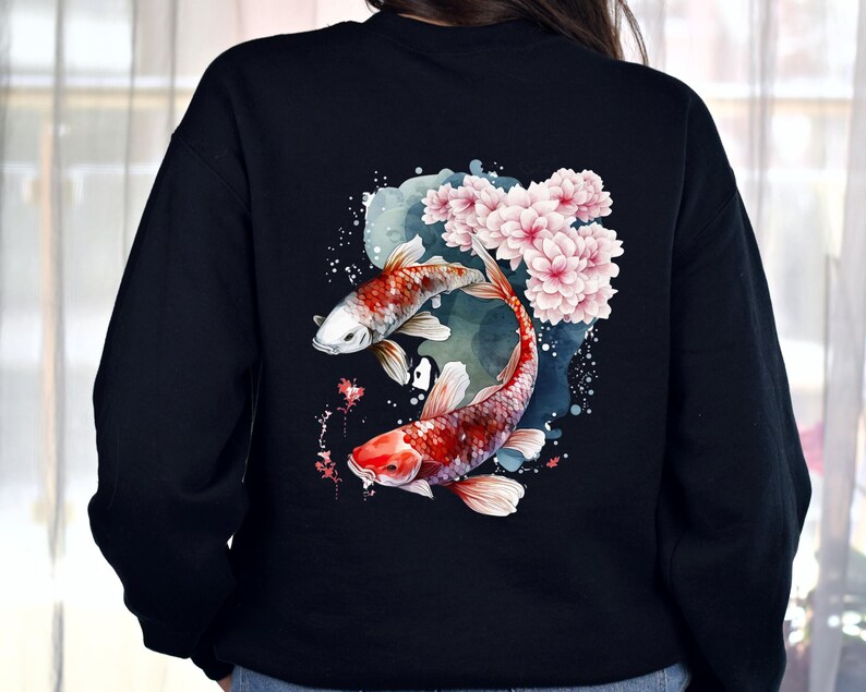 Puede incluir: Sudadera negra con un dise&ntilde;o de acuarela de dos peces koi nadando entre flores de cerezo rosas.