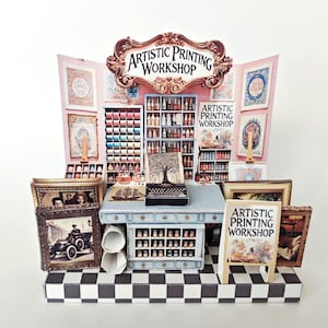 May include: A miniature shop display with a sign that reads "Artistic Printing Workshop". The shop has shelves filled with bottles and jars, a printing press, and framed artwork. The shop is decorated with a chequered floor and a pink and white striped wall.