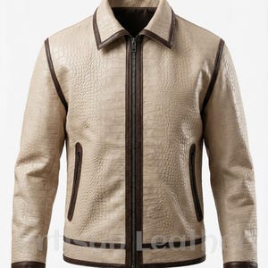 Puede incluir: Chaqueta de cuero beige con efecto piel de cocodrilo. La chaqueta tiene cremallera, cuello y ribetes marrón oscuro. Cuenta con dos bolsillos laterales y un diseño clásico. Una prenda de vestir elegante.