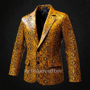 Pode incluir: Um blazer amarelo e preto com padrão de pele de cobra e fecho de dois botões. O casaco tem lapelas entalhadas, dois bolsos frontais e mangas compridas. O texto "Artisaneather" é visível no canto inferior direito.