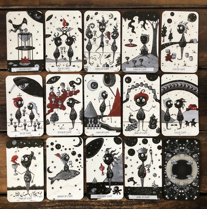 May include: A set of 14 tarot cards featuring black and white illustrations of whimsical characters with cups. The cards are numbered from Ace to King and include a Knight and Queen card. The cards are part of a tarot deck.