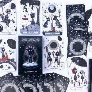 May include: A black and white tarot deck with a dark, starry background. The cards feature illustrations of various characters and symbols. The deck is titled "Cosmobeings Tarot Deck" and is by Joanna Nelson.