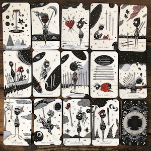 May include: A set of 14 tarot cards featuring black and white illustrations of swords and figures. The cards are part of a tarot deck called "The Swords".