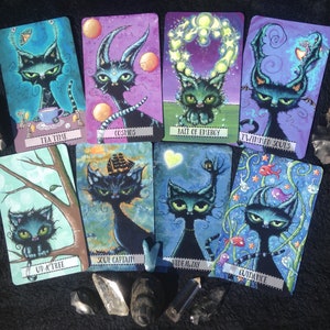 May include: A set of ten illustrated cards featuring black cats with different backgrounds and text. The cards include "Tea Time", "Up a Tree", "Cosmos", "Bait of Energy", "Twinned Souls", "Soul Captain", "Hideaway", "Guidance", "The Moon", and "The Sun".