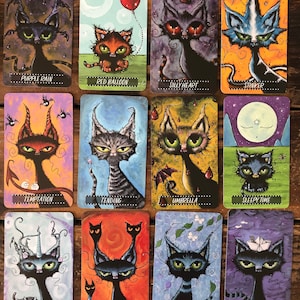May include: A set of 12 illustrated cards featuring black cats with various whimsical details, such as a red balloon, an umbrella, and a unicorn horn. Each card has a different title, including "Purple Rain", "Red Balloon", "Silly Heart", "Stinker", "Temptation", "Tending", "Umbrella", "Sleepy Time", "Ahoy There", "Unicorn", "Voices", and "Winds of Change".
