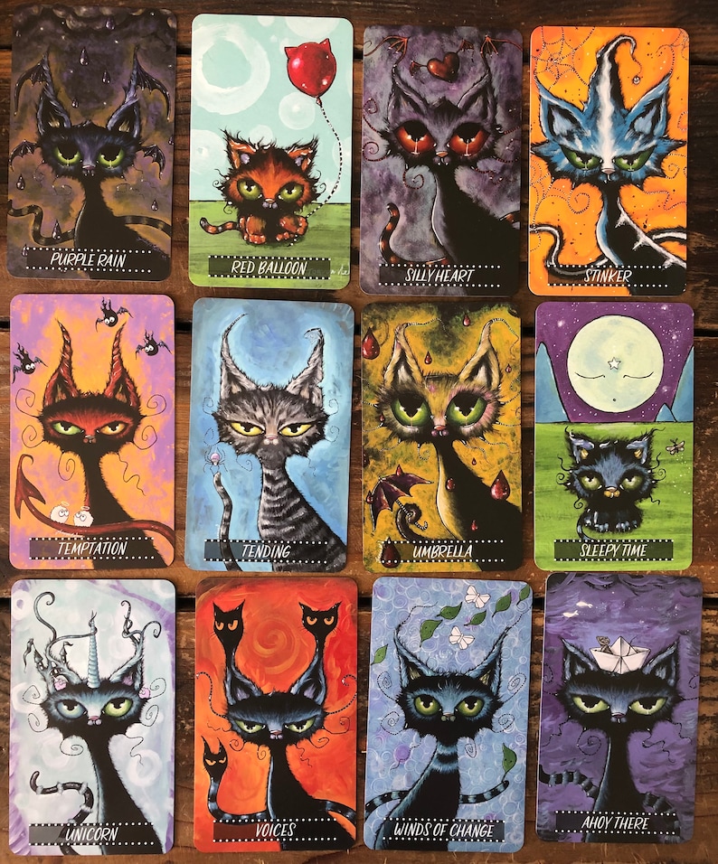 May include: A set of 12 illustrated cards featuring black cats with various whimsical details, such as a red balloon, an umbrella, and a unicorn horn. Each card has a different title, including "Purple Rain", "Red Balloon", "Silly Heart", "Stinker", "Temptation", "Tending", "Umbrella", "Sleepy Time", "Ahoy There", "Unicorn", "Voices", and "Winds of Change".