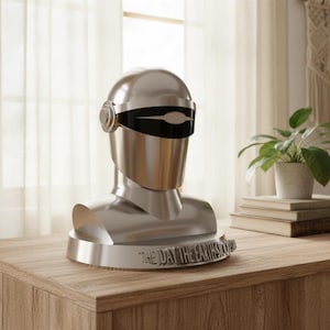 May include: A metallic silver bust of a robot with a black visor. The bust is on a circular base with the text "THE DAY THE EARTH STOOD STILL". The bust is displayed on a wooden table.