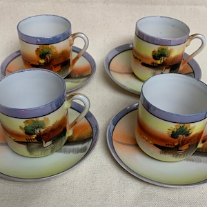 May include: Set of four vintage teacups and saucers with a hand-painted design of a landscape with trees and a house. The cups and saucers are white with a light blue rim and a yellow, orange, and green landscape design.