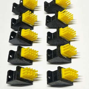 Op de afbeelding: Tien zwarte en gele hoekbeschermers met een borstelstructuur. De beschermers zijn ontworpen om hoeken te beschermen tegen beschadiging.