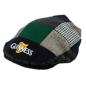 May include: A patchwork flat cap in a variety of fabrics and patterns, including green, navy, grey, and white. The Guinness logo is embroidered on the front. A traditional style of hat, suitable for casual wear.