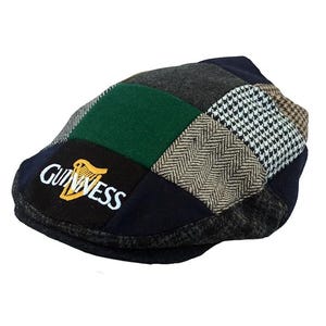 May include: A patchwork flat cap in a variety of fabrics and patterns, including green, navy, grey, and white. The Guinness logo is embroidered on the front. A traditional style of hat, suitable for casual wear.