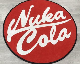 May include: A red round rug with the words "Nuka Cola" in white cursive lettering.