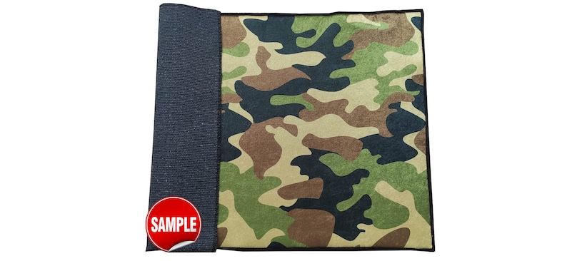 May include: A camouflage fabric sample with a black border. The fabric has a green, brown, and black camouflage pattern. The word "SAMPLE" is printed in red on a white sticker.