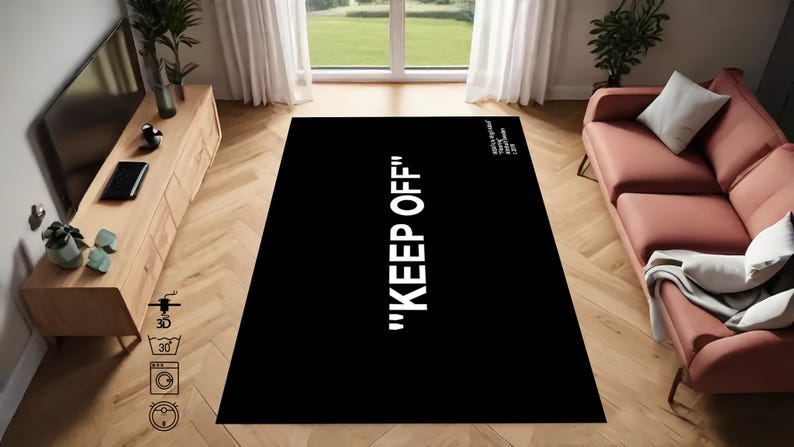 Puede incluir: Alfombra de &aacute;rea negra y blanca con el texto "KEEP OFF" en letras blancas. La alfombra est&aacute; en un ambiente de sala de estar con un sof&aacute; y un centro de entretenimiento de madera.