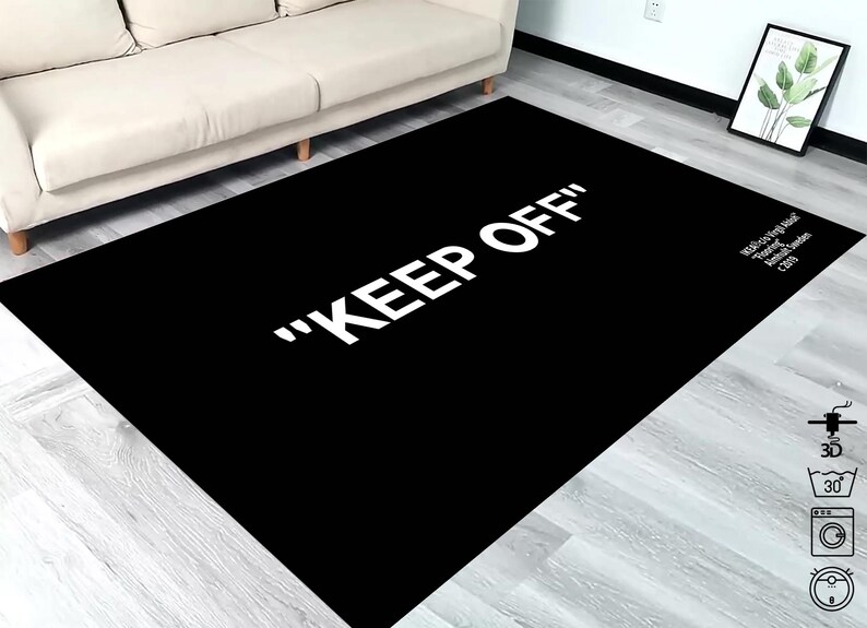 Puede incluir: Alfombra negra y blanca con el texto "KEEP OFF" en letras blancas. La alfombra est&aacute; sobre un suelo de madera clara.