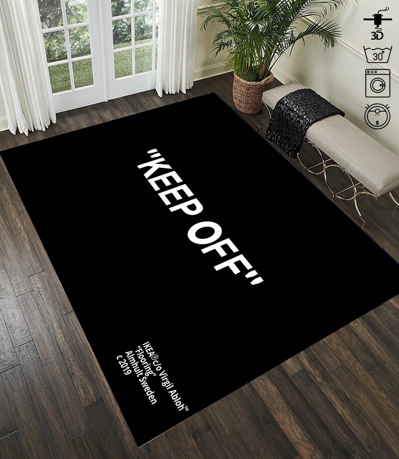 Puede incluir: Alfombra negra y blanca con el texto "KEEP OFF" en letras blancas. La alfombra tambi&eacute;n incluye el texto "IKEA&reg;c/o Virgil Abloh&trade;" "Flooring" "Almhult Sweden" "c 2019" en letras blancas.