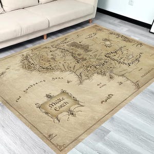 Puede incluir: Una alfombra beige y marrón con un mapa de la Tierra Media impreso en ella. El mapa incluye el texto "Middle Earth" y "the Sundering Seas".