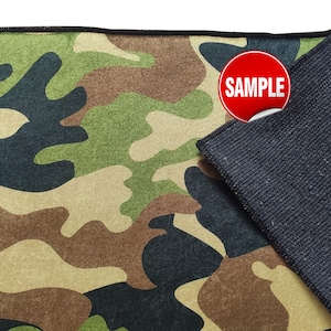 May include: A camouflage fabric mouse pad with a black non-slip backing. The pad has a red circle with the word "SAMPLE" printed on it.