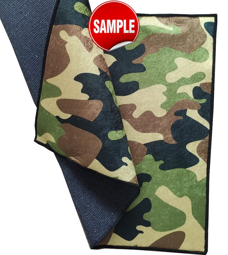 May include: A green, brown, and black camouflage microfiber cleaning cloth with a black border. The cloth is folded in half and the word "SAMPLE" is printed on a red circle sticker.