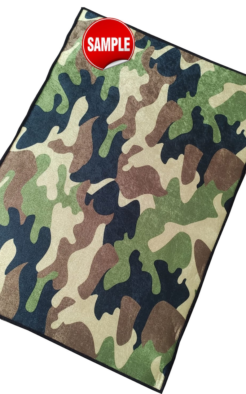May include: A camouflage fabric with a black border. The fabric has a textured, fuzzy surface. The word "SAMPLE" is printed in white on a red circle.