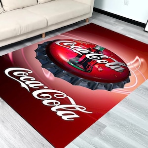 Op de afbeelding: Rood en wit Coca-Cola tapijt met een groot ontwerp van een flessen dop. De flessen dop is 3D en heeft een rood en wit Coca-Cola logo.