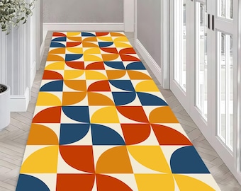 May include: A rectangular hallway rug with a geometric pattern. The rug features a repeating design of quarter-circle shapes in shades of yellow, orange, red, and blue, set against a cream background. The rug is placed in a hallway with white doors and walls.