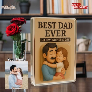 May include: A clear acrylic block with a 3D image of a father and child hugging, with the text "BEST DAD EVER" and "HAPPY FATHER'S DAY". A small photo is displayed on the left. Red roses in a glass vase are on the left.