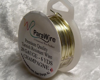May include: A spool of ParaWire brand tarnish-resistant wire in champagne color. The label reads "20 GAUGE - 6 YDS." The wire is wound around a clear plastic spool with a handle.