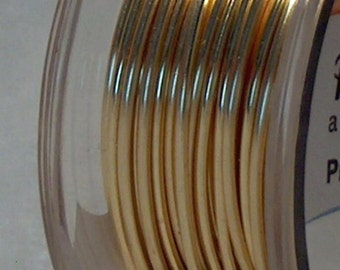 May include: Close-up of a spool of gold-colored wire. The wire is tightly wound and appears to be made of a shiny, metallic material. The spool is partially visible, with a clear plastic side.