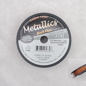 May include: A spool of copper colored Soft Flex Metallic Flex Wire, labeled "Fine" and "Soft Materials - Seed Beads & Freshwater Pearls". The spool is 30 feet long and has a diameter of 0.014 inches. The wire is made in the USA.