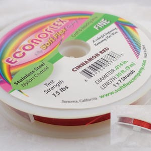 May include: A spool of cinnamon red soft flex wire, stainless steel, nylon coated, with a test strength of 15 lbs. The spool is labeled with the brand name "EconoFlex", the color "Cinnamon Red", the diameter ".014 in", the length "30 ft. (9 m)", and the number of strands "1 x 7".