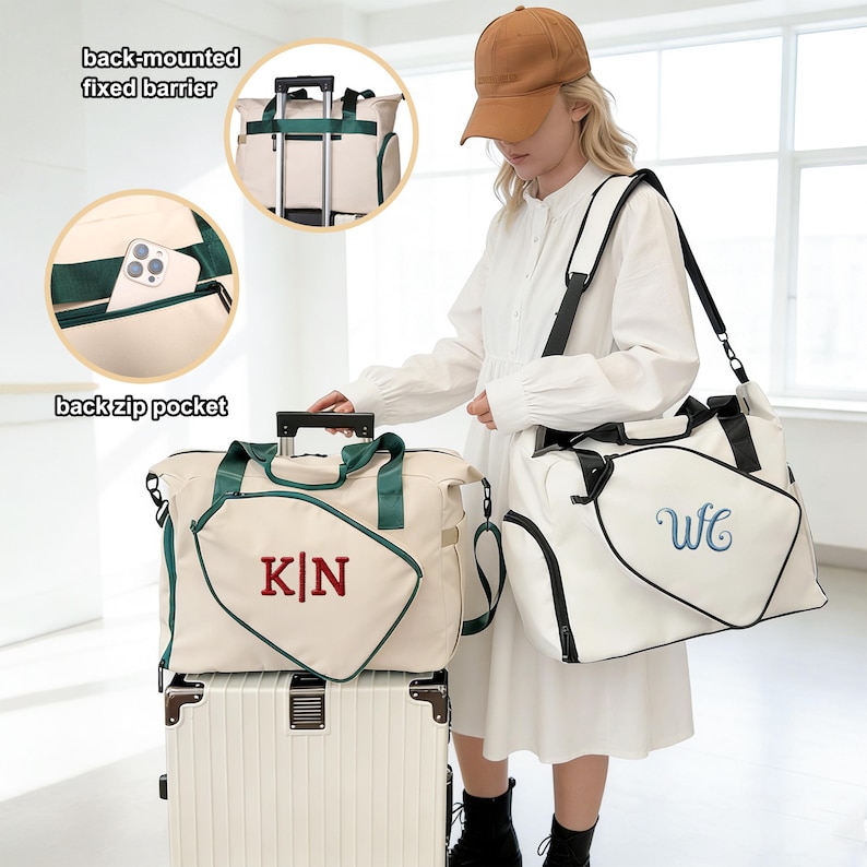 K&ouml;nnte beinhalten: Cremefarbene Reisetaschen mit gr&uuml;nen und schwarzen Akzenten. Eine Tasche hat "KN" in Rot gestickt, eine andere "WfC" in Blau. Zu den Merkmalen geh&ouml;ren eine Rei&szlig;verschlusstasche hinten und eine fest montierte Barriere hinten. Die Taschen stehen auf einem wei&szlig;en Koffer.